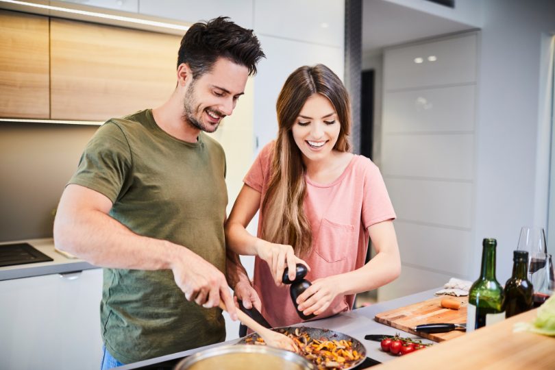 Husband and wife cooking dinner together in their new townhome they purchased