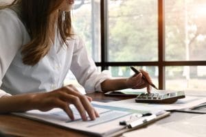 woman at her desk with calculator and documents