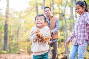 happy kids with fall leaves in his hands
